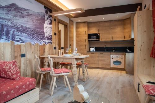 利维尼奥AG Apartments Livigno centro的厨房以及带桌椅的起居室。