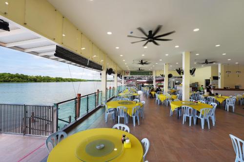 瓜拉雪兰戈Hotel Le-Shore的船上的餐厅,配有黄色的桌椅
