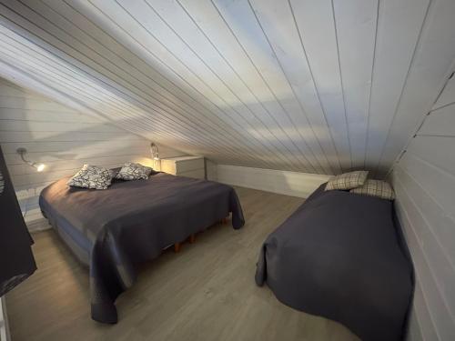 索特Syöte Luppomaja的客房设有两张床和天花板。