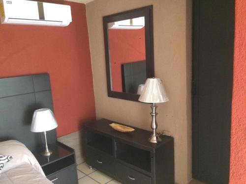 Emiliano ZapataVilla Paraiso的一间卧室配有床、镜子和灯