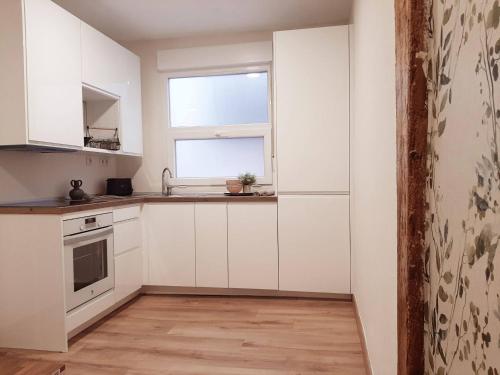桑坦德Precioso apartamento en el centro de Santander的厨房配有白色橱柜和窗户。