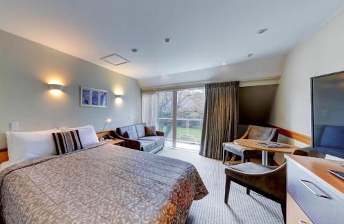 但尼丁Dunedin Leisure Lodge - Distinction的配有一张床和一台平面电视的酒店客房