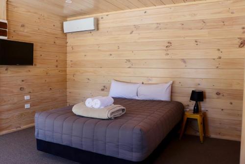 特卡波湖Lakes Edge Lodge的一间卧室配有一张床,上面有两条毛巾