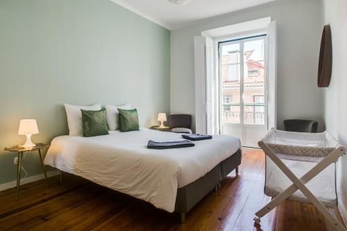 里斯本Spacious, Bright and Newly Renovated 2 Bedroom Apartment, Lisbon Historical Center, Madragoa的一间卧室设有一张大床和一个窗户。