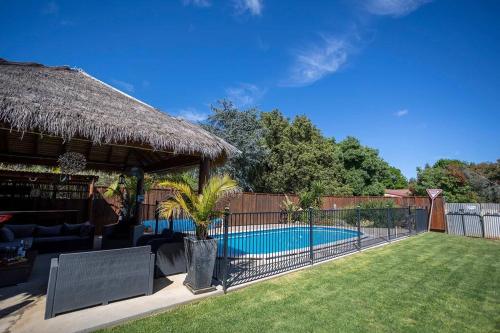 帕克斯Contractor's Heaven and Entertainer的一个带游泳池和草屋的后院