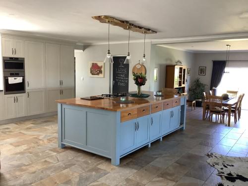 克尼斯纳Pezula Golf House的厨房配有白色橱柜和木制台面