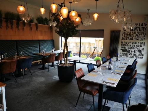 爱丁堡The Balerno Inn的一间设有桌椅和盆栽的餐厅