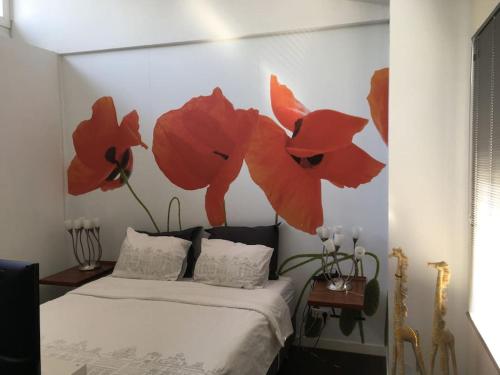 阿默斯福特modern genieten in oud binnenstadspand的卧室配有一张挂着红色鲜花的床。
