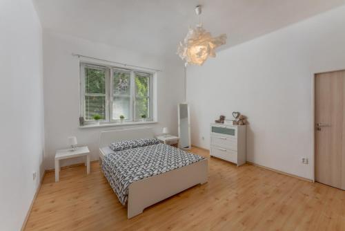 奥洛穆茨Apartmán s terasou的白色的卧室设有床和窗户