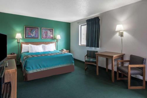 新斯坦顿速8新斯坦东酒店的酒店客房,配有一张床、一张桌子和椅子