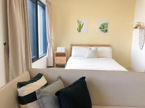 乔治市Tropicana 218 Macalister Netflix Seaview的一间卧室配有一张床和一张带枕头的沙发。