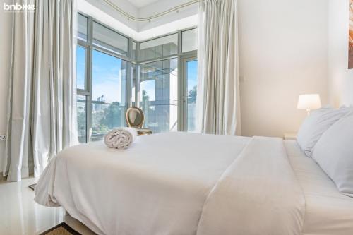 迪拜bnbmehomes - Great Value Spacious Apartment w Moden Furniture - 103的白色卧室设有一张大床和窗户