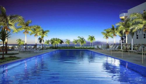 帕纳米林Resort In Mare Bali - Apto lado da sombra的一座大型游泳池,在一座建筑前种有棕榈树