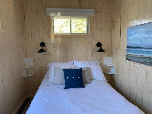 梅戈格Chalets Memphrémagog的一间卧室配有一张带蓝色枕头的床