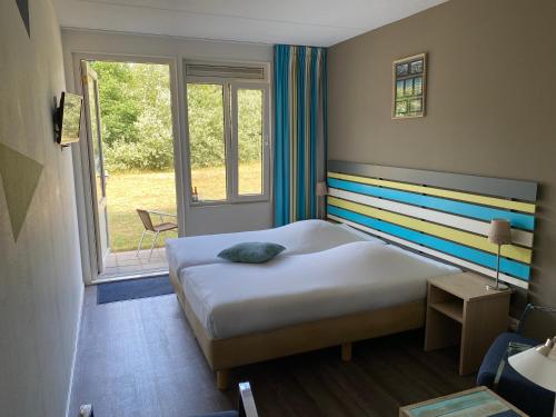 东弗利兰多尼亚斯德特酒店的一间卧室配有一张带彩色条纹床头板的床