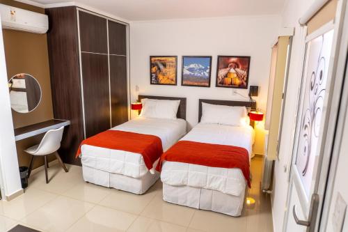 门多萨Hotel Dalai的一间卧室配有两张红色和白色床单