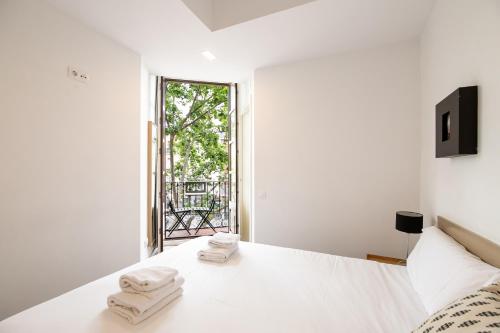 巴塞罗那Decô Apartments Barcelona-Sants的白色卧室,配有带毛巾的床