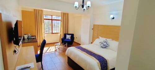 内罗毕Hays Suites Hotel的酒店客房配有一张床、一张桌子和一把椅子。