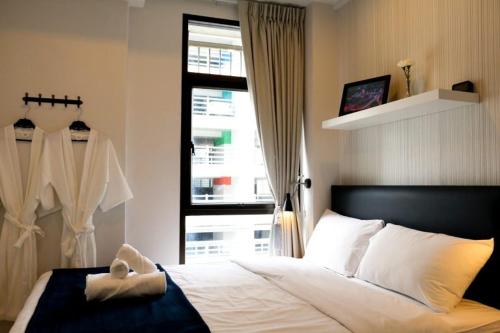 曼谷The Urban Age DeLuxe的一间卧室设有一张大床和一个窗户。