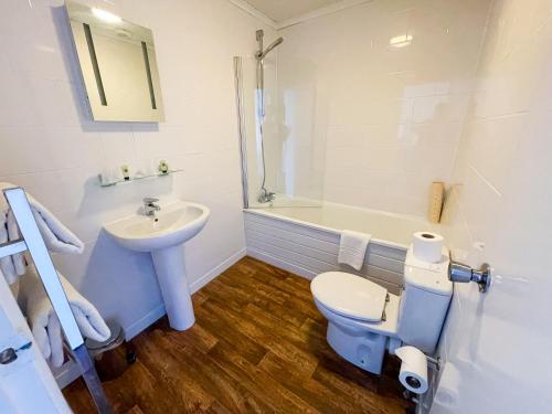 安德沃The Star and Garter Hotel的浴室配有盥洗盆、卫生间和浴缸。
