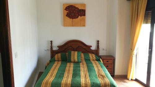埃尔博斯克Casa Las Truchas的一间卧室配有一张带绿色和黄色毯子的床