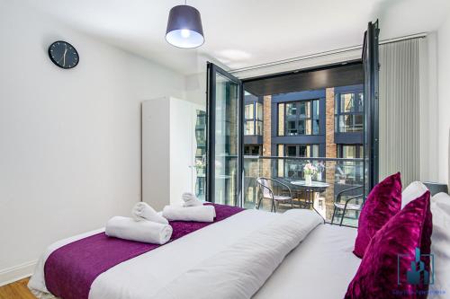 伯明翰City View Apartments的卧室配有一张带紫色枕头的大型白色床。