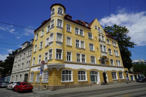 慕尼黑HOMELY STAY Studio 1的城市街道上的一座黄色和白色的建筑