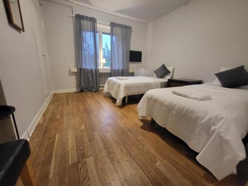 韦斯特罗斯IzKaMaGe Hotel 2的一间卧室设有两张床,铺有木地板