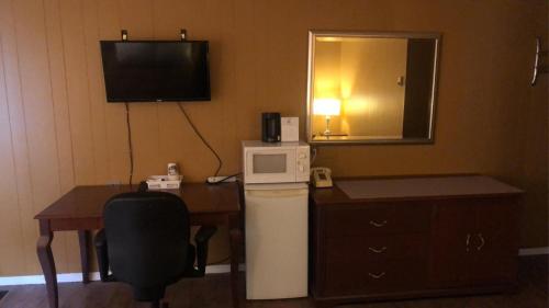 Smooth Rock FallsMoose Motel的酒店客房配有书桌、冰箱和电视。