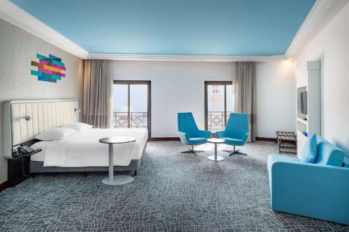 麦加麦加爱娜森瑞迪森帕克酒店的酒店客房,配有床和蓝色椅子