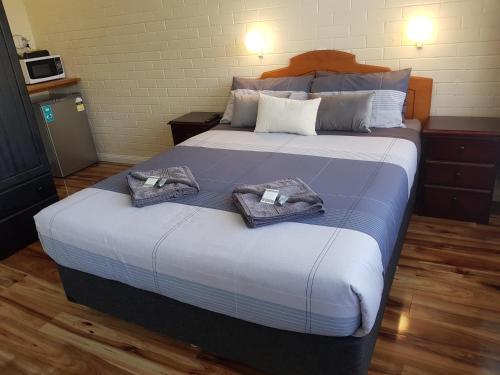 怀阿拉怀阿拉乡村汽车旅馆的一间卧室配有一张大床和毛巾