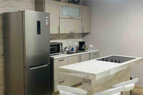 亚武科阿Hollywood Apartments的厨房配有不锈钢冰箱和水槽