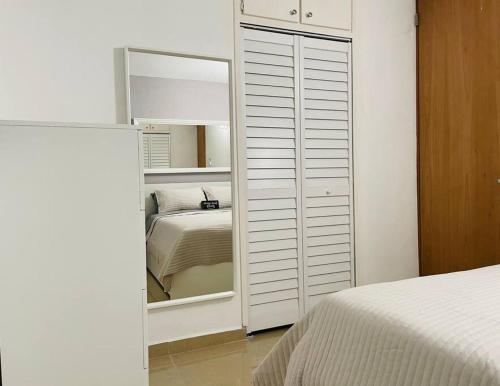 亚武科阿Hollywood Apartments的一间卧室配有带镜子的衣柜和一张床