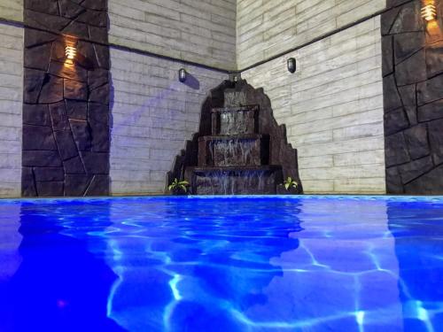 巴拉奈里奥-坎布里乌Casa com piscina em Balneário Camboriú的一座蓝色海水室内游泳池,位于一座建筑中