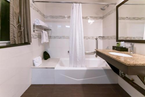 纽约麦迪逊LES酒店的白色的浴室设有浴缸和水槽。