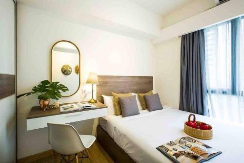 当格浪NOCHE - 2 bedroom Skyhouse Apartment BSD的酒店客房配有一张带书桌和镜子的床。