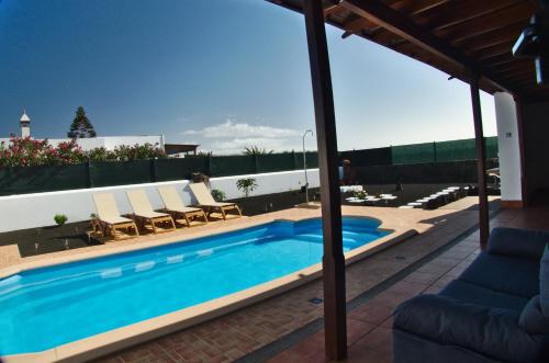 普拉亚布兰卡Villa Raima的一个带躺椅的游泳池和一个庭院