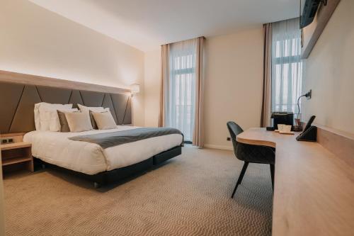布鲁塞尔Hôtel Concorde的配有一张床和一张书桌的酒店客房