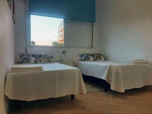 厄尔梅达诺Apartamento Brisa de El Médano VV的带窗户的客房内的两张床