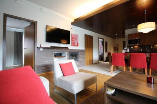 塔库沃里Tahko SPA Luxury Suite Orange B5 with Mountain View的客厅配有红色沙发和红色椅子