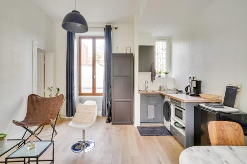 塞纳河畔伊夫里Appartement charmant entièrement équipé的一间厨房,里面配有桌椅