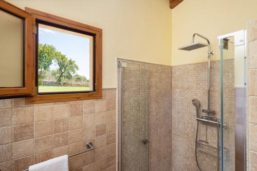 圣玛加利达Alcudiola的带淋浴的浴室和窗户。