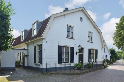 阿莫隆根La Vie en Roos Amerongen的街上的白色房屋,设有黑窗