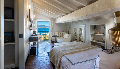 圣特罗佩Le Yaca Saint-Tropez的一间带两张床的卧室,享有海景