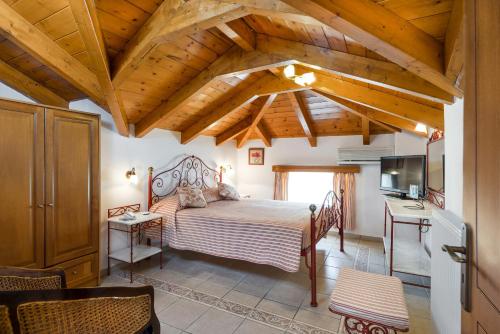 蒂锡利维安得里奥拉斯豪华套房酒店的一间带一张床的卧室,位于带木制天花板的房间内