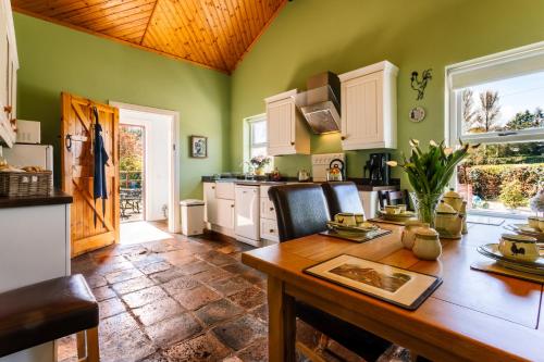 利斯本布鲁克豪小屋酒店的厨房设有绿色的墙壁和木桌