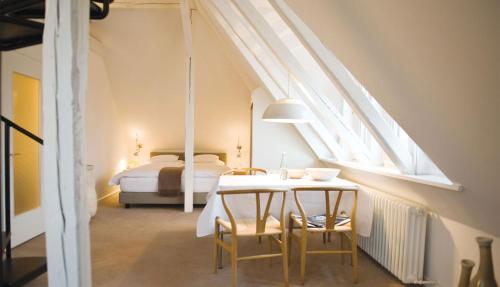 诺德奈Hotel Haus Norderney的卧室配有一张床和一张桌子及椅子