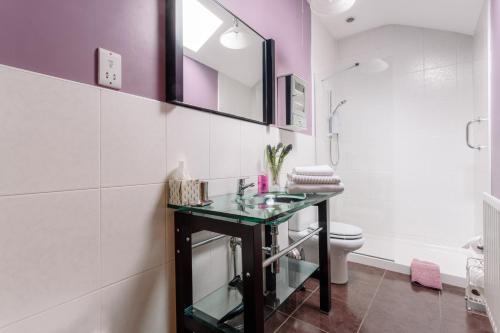 利斯本布鲁克豪小屋酒店的一间带玻璃水槽和卫生间的浴室