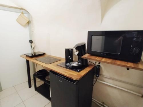 圣保罗三堡Studio - Fontaine的一张带微波炉的桌子和一台电视机