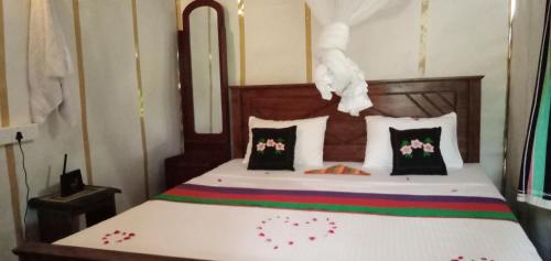 锡吉里亚Sigiri Panaromic Tree House的一间卧室,床上放着鲜花